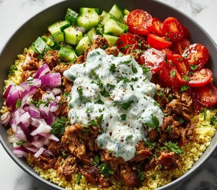 Delicious ground turkey gyro bowl topped with fresh vegetables and tzatziki sauce.