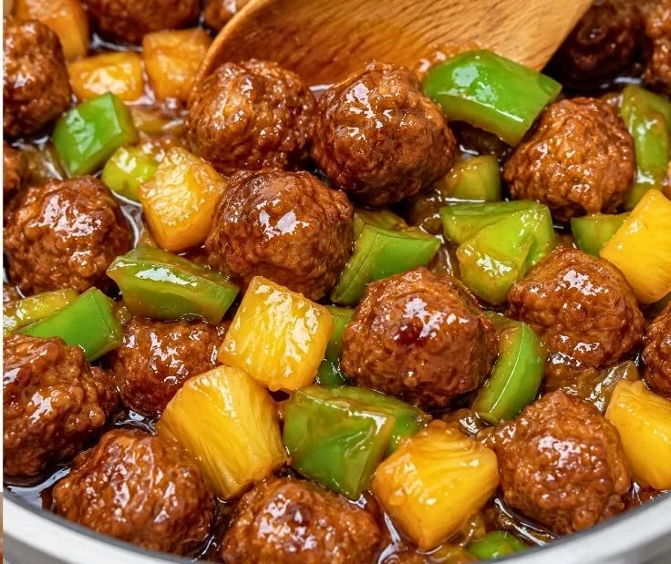 Delicious Hawaiian meatballs served on a plate with pineapple and rice