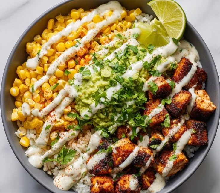 Healthy street corn chicken bowl garnished with fresh herbs and toppings